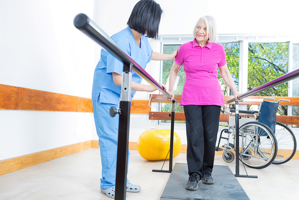 A therapist guiding a resident through a rehabilitation exercise at an Advinia Care community